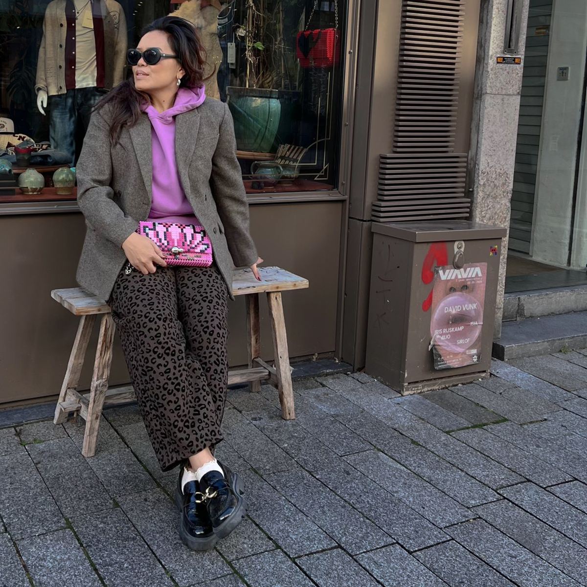 Een getailleerde blazer over een roze hoodie, met een wijde broek eronder