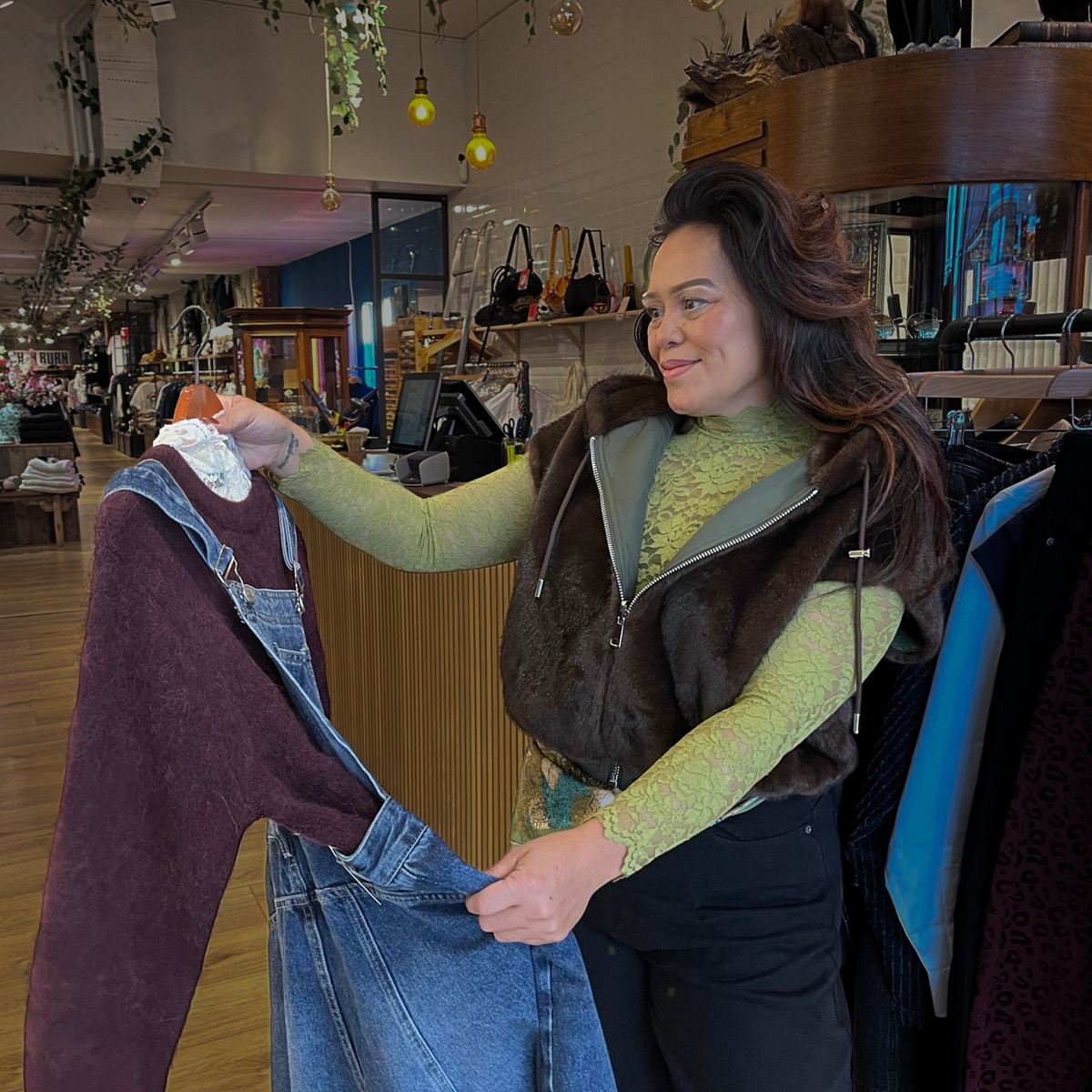 Sabrina met een kort bontjasje aan, stylend bij het rek in de winkel